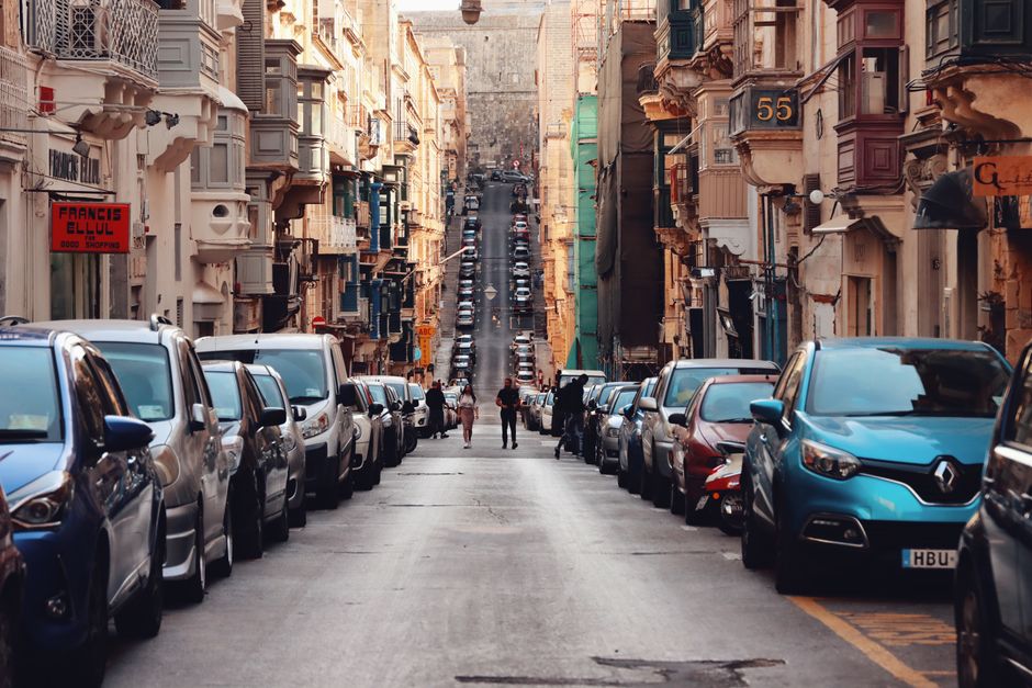 A narrow residential street in Parsons Green with closely packed parked cars lining both sides of the road, including a mixture of compact hatchbacks and larger vehicles, some with visible roof racks.